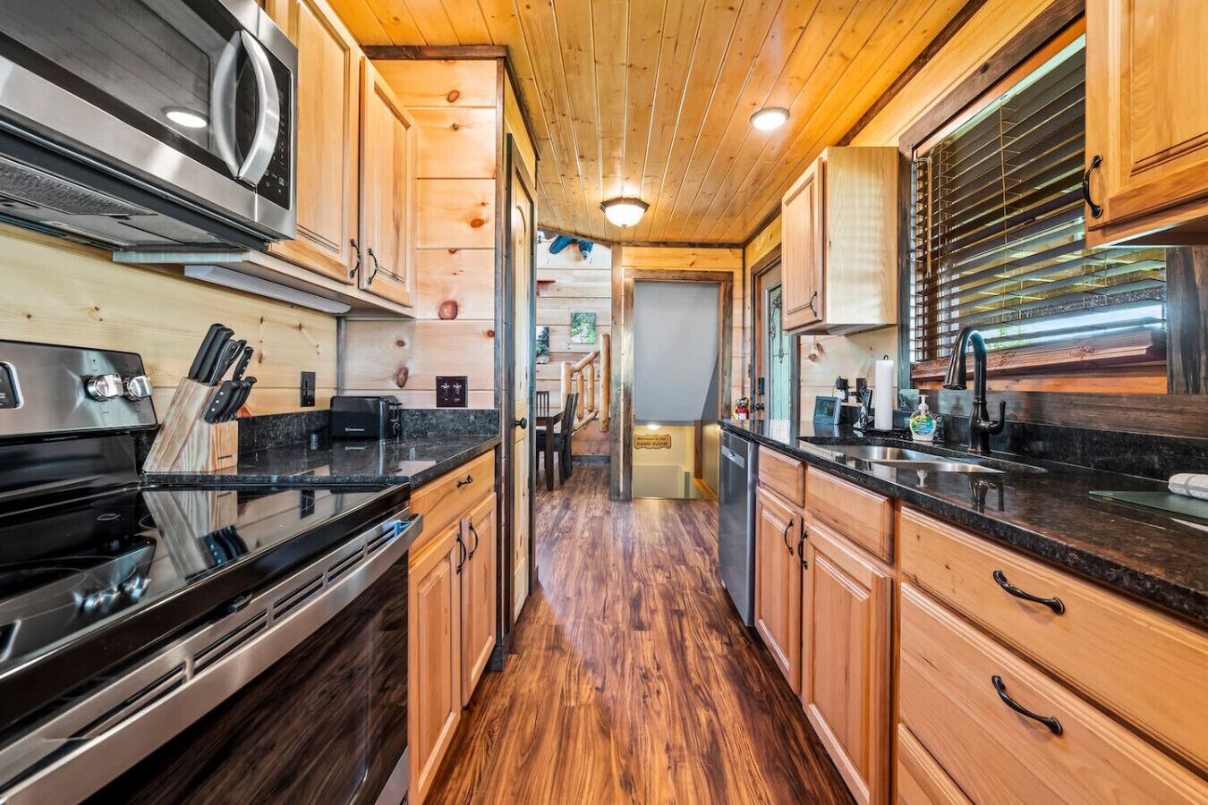 A modern kitchen with wooden cabinets, stainless steel appliances, and a central island.