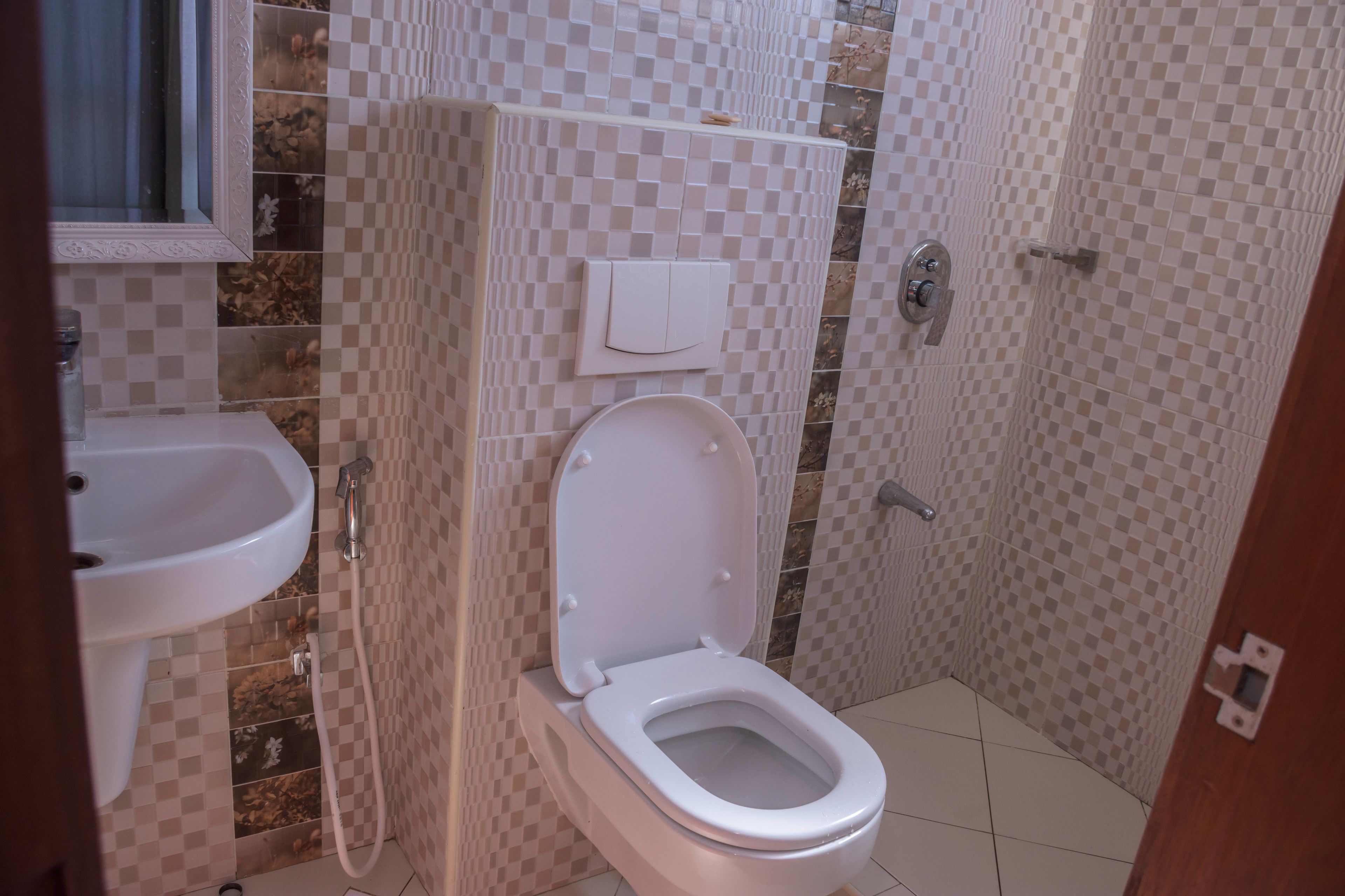 A bathroom with a toilet, sink, and shower.