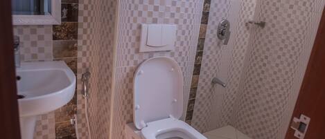 A bathroom with a toilet, sink, and shower.