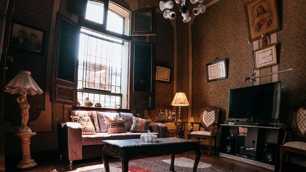 A cozy living room with a wooden ceiling, a sofa, a coffee table, and a fireplace. - Samanai Wasi Hostel  (Lima)