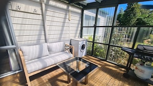 A balcony with a sofa, a washing machine, and a grill. - Somers holiday cottage (Mt Somers)
