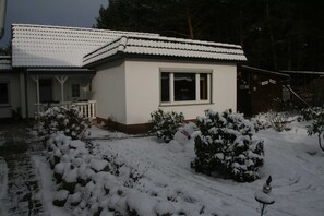 A white building with a tiled roof, a window, and a porch.