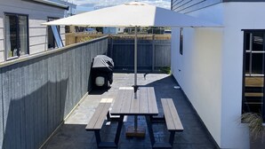 A patio area with picnic tables and a barbecue grill.