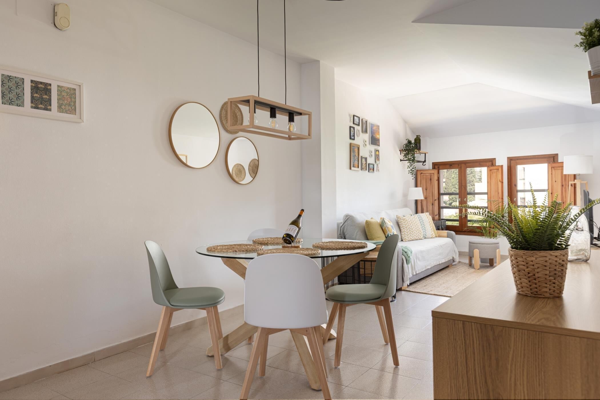 Une cuisine moderne avec une table à manger, des chaises et un luminaire suspendu.