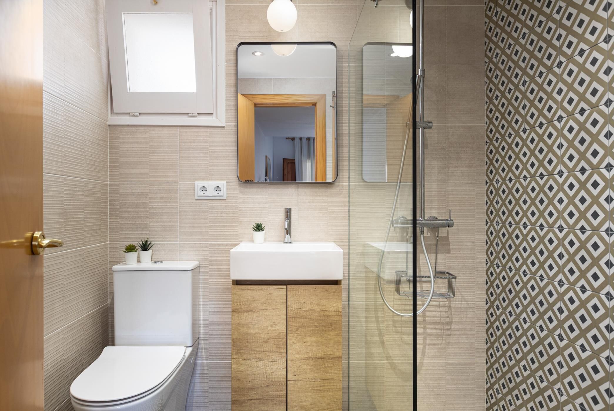 Een moderne badkamer met toilet, wastafel en douche.
