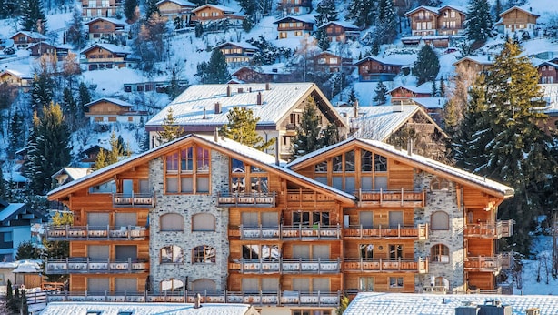 A multi-story chalet with balconies, stone facade, and snow-covered surroundings. - Ferme de Sandra F2 by Interhome (Nendaz)