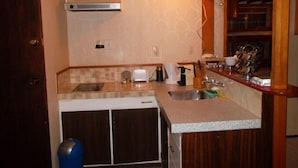 Una cocina compacta con lavavajillas, pileta doble y una pequeña mesada.