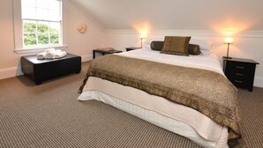Camera da letto con un letto grande, due comodini, un tavolino e una piccola panca con asciugamani.