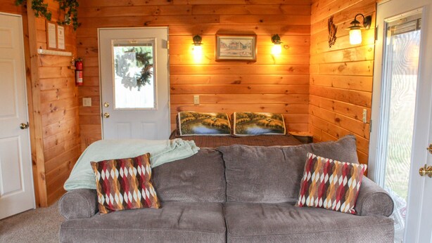 Una habitación acogedora con detalles de madera, una cama con vistas y una puerta decorada con un adorno.