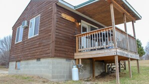 Una cabaña de madera con balcón y una pequeña construcción adosada.