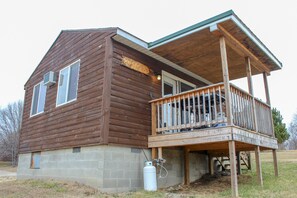 Eine Holzhütte mit Balkon und einem kleinen Anbau.