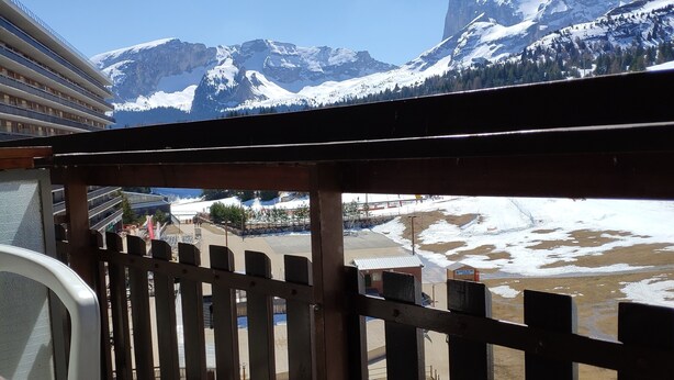 Ein Balkon mit Blick auf schneebedeckte Berge und ein Kreuzfahrtschiff im Hintergrund.