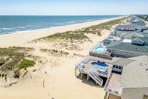 Uma propriedade à beira-mar com piscina, várias varandas e vista para o oceano.