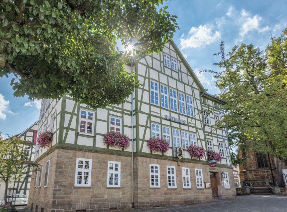 Ein traditionelles Fachwerkhäuschen mit vielen Fenstern und Blumenkästen im Erdgeschoss.