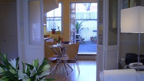 A dining area with a table and chairs, a white sofa, and a lamp.
