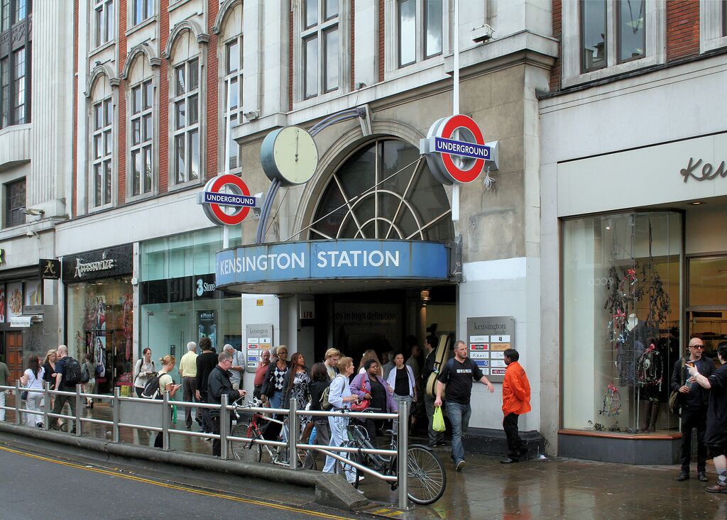 Kensington Station med en menneskemængde, et ur og en butik ved navn 'Kensington'.