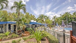 A resort with outdoor seating, palm trees, and a pool.
