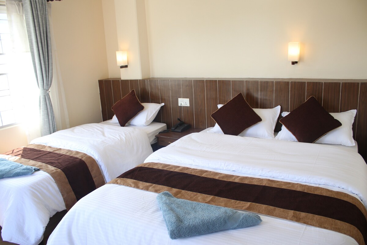 Two beds with headboards, bedside tables, and wall-mounted lamps.