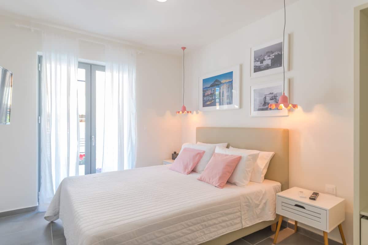 Une chambre à coucher avec un lit, des tables de chevet et une fenêtre avec des rideaux.