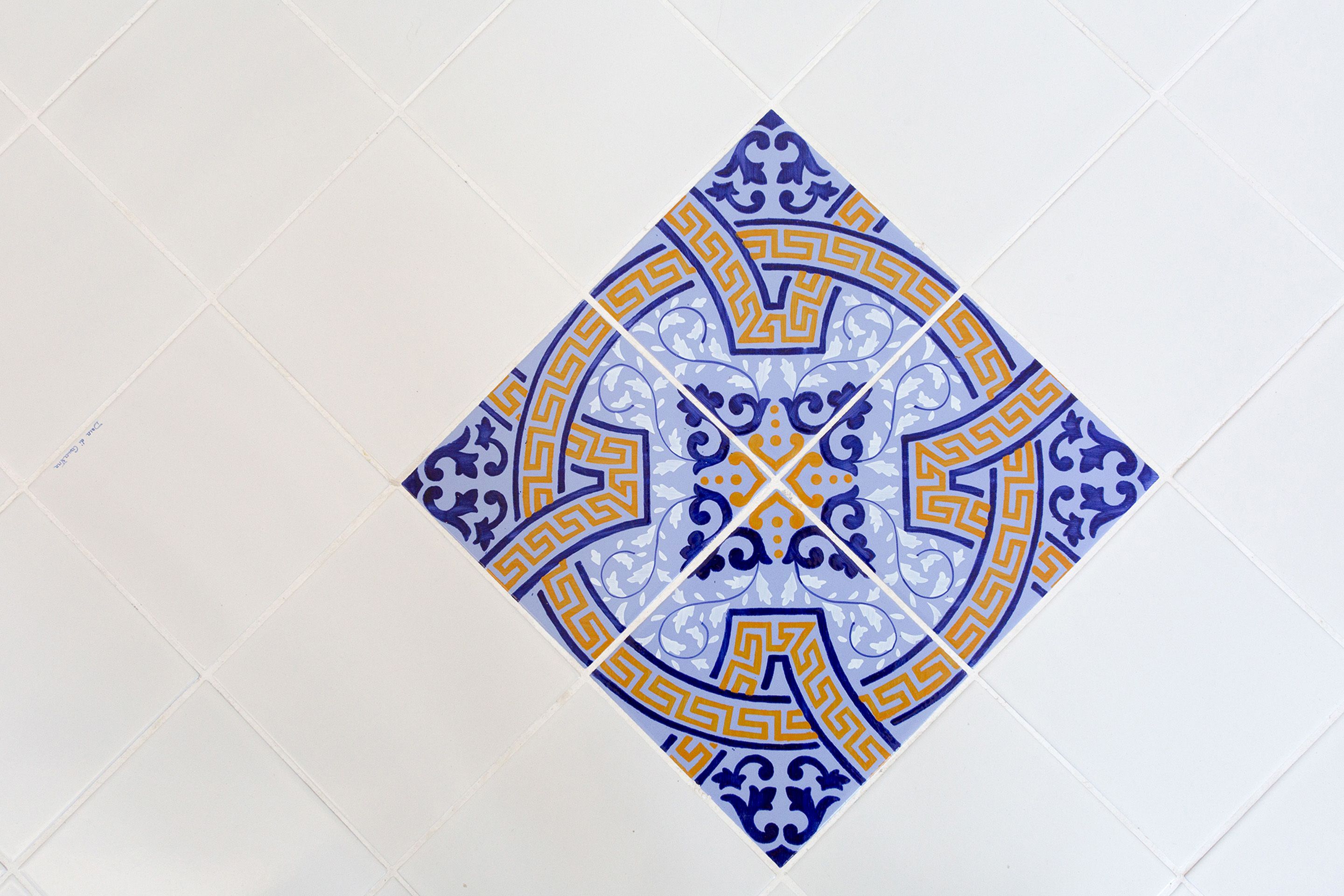 Un motivo geometrico a piastrelle con una stella al centro e decorazioni circostanti.