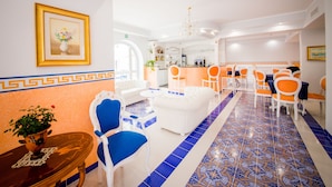 A hotel lobby with a dining area, a reception desk, and a bar. - Odysseus Hotel (Lipari)