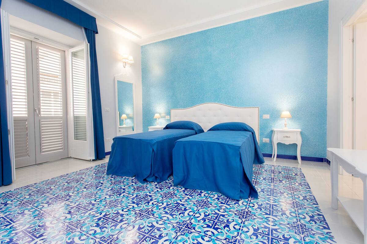 A bedroom with a large bed, two bedside tables, and a nightstand.