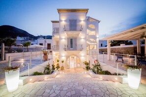 A multi-story building with a central entrance, balconies, and outdoor seating areas. - Odysseus Hotel (Lipari)