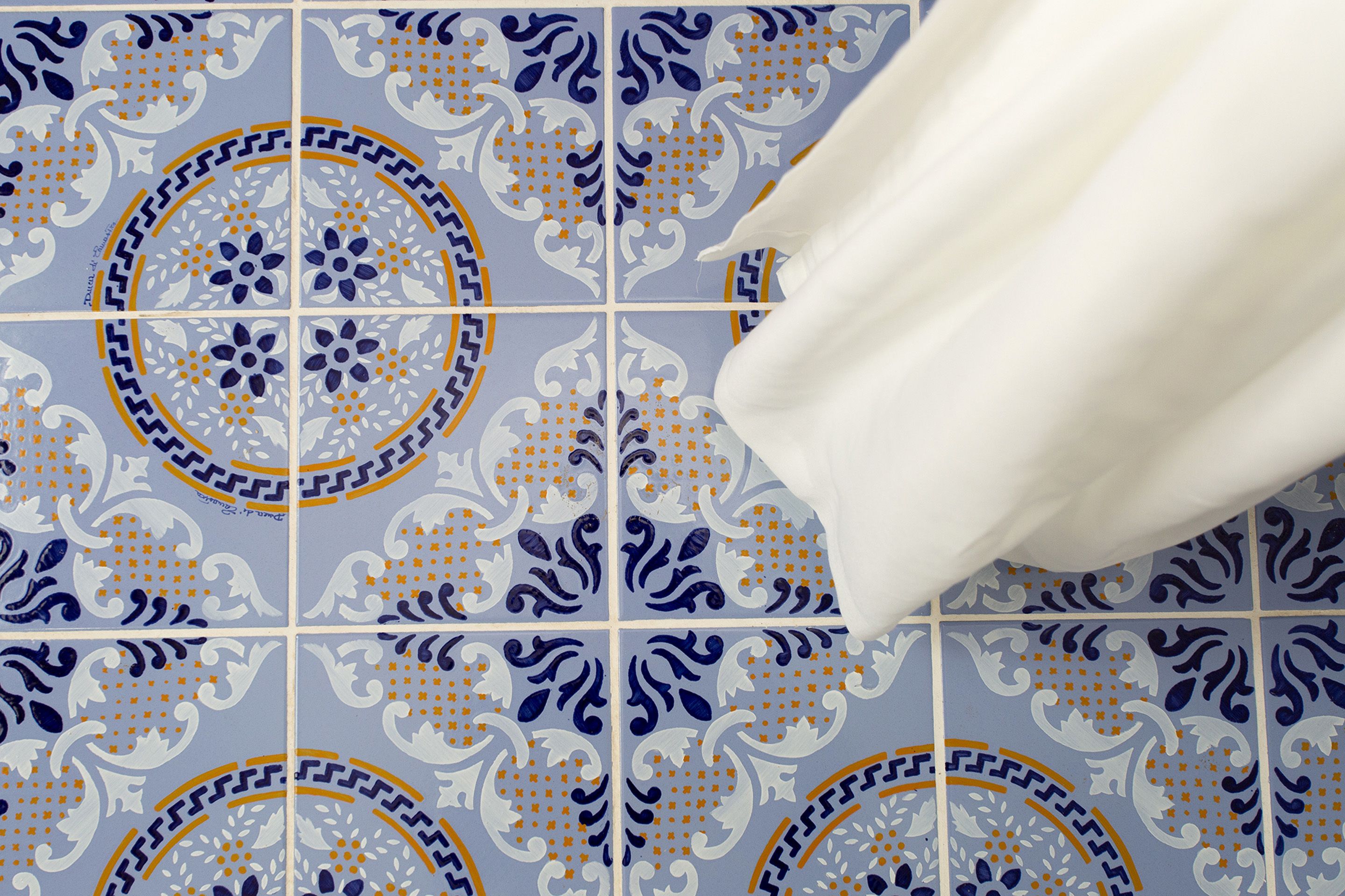 Een betegelde muur met een decoratief patroon.