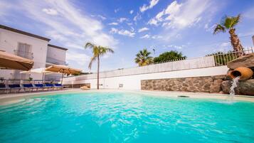 Seasonal outdoor pool, a waterfall pool, pool umbrellas, sun loungers