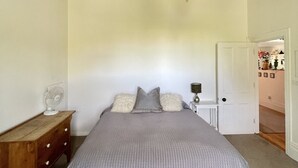 Une chambre à coucher avec un grand lit, un plafond en bois et un lustre.