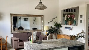 Une cuisine moderne dotée d’un plan de travail en granit, de meubles blancs et d’un lave-vaisselle encastré.