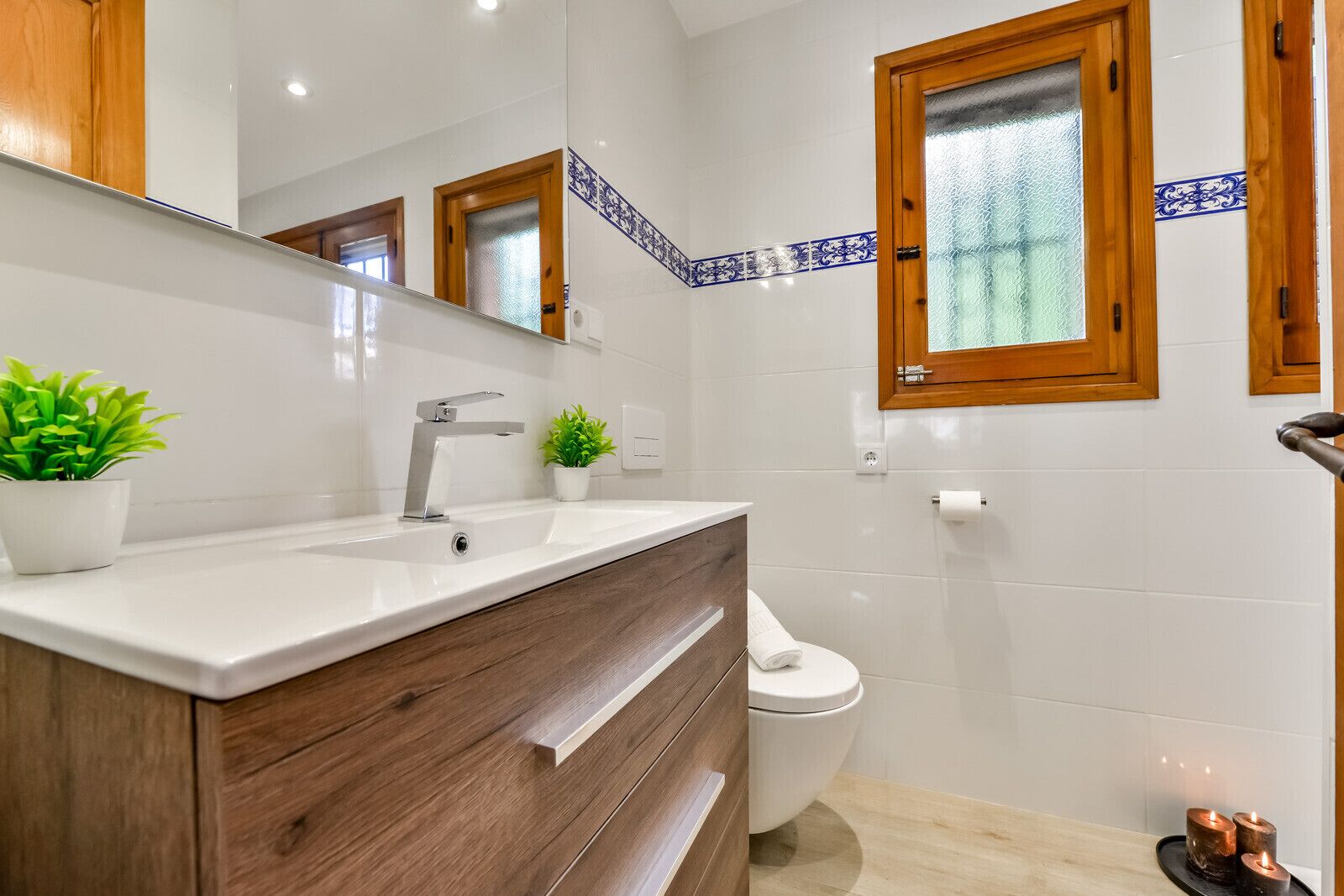 Une salle de bain moderne avec un lavabo blanc, un meuble-lavabo en bois et des toilettes.