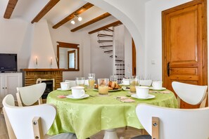 Enjoy breakfast at a beautifully set table with a fireplace nearby.