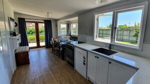 Una cocina compacta con comedor, horno empotrado y un ventanal con vistas al jardín.