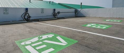 A parking area with electric vehicle charging stations and designated parking spaces for EVs.