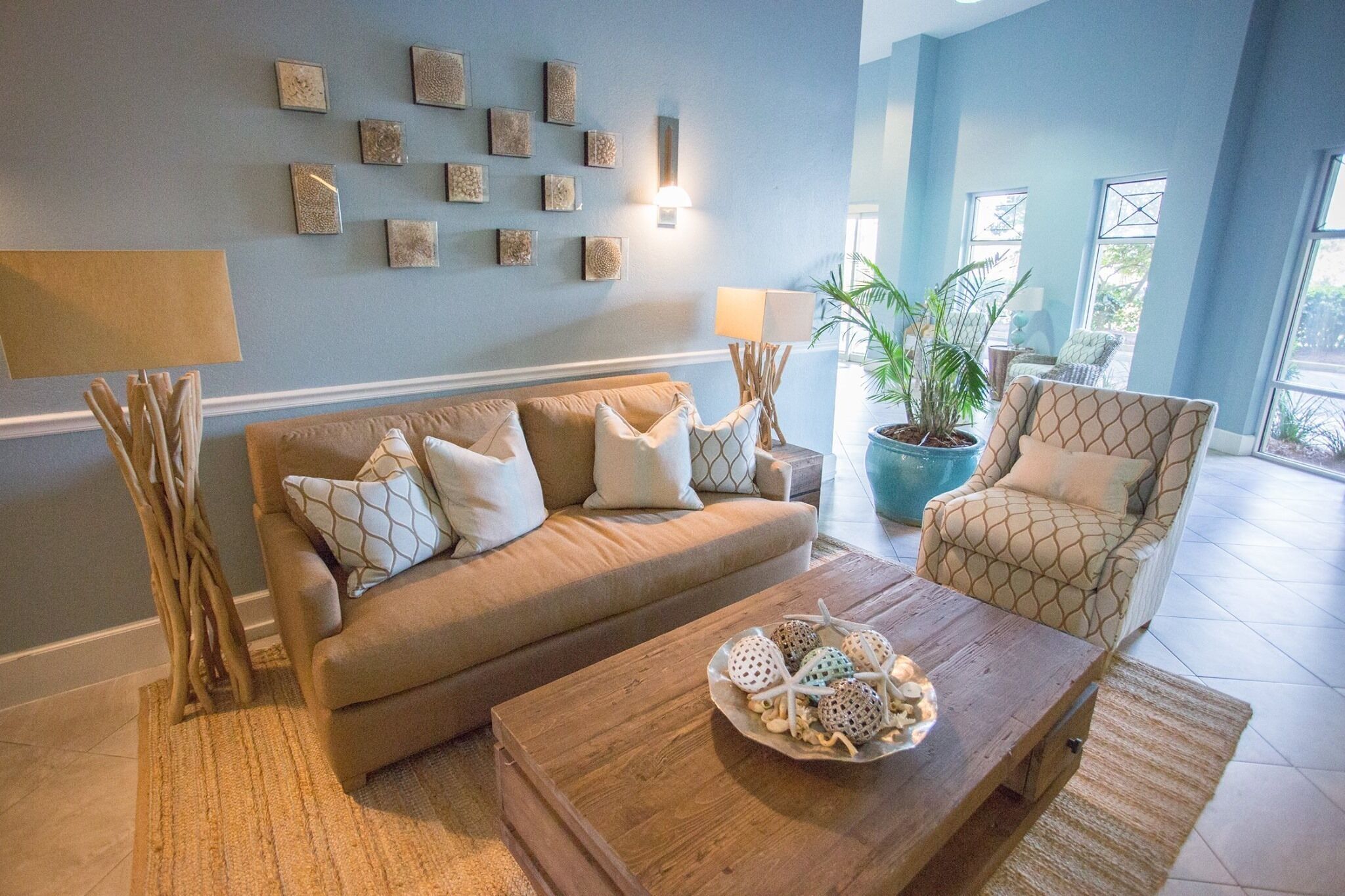 Ein Wohnzimmer mit Sofa, Sesseln, Couchtisch und Wandbildern.