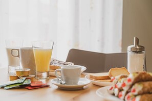 A breakfast table with a pitcher, glasses, a cup, toast, and a bottle. - B&B Alle Falde Dell'Etna (Zafferana Etnea)