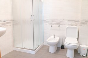 A modern bathroom with a glass-enclosed shower, a bidet, a toilet, and a trash bin. - B&B Alle Falde Dell'Etna (Zafferana Etnea)