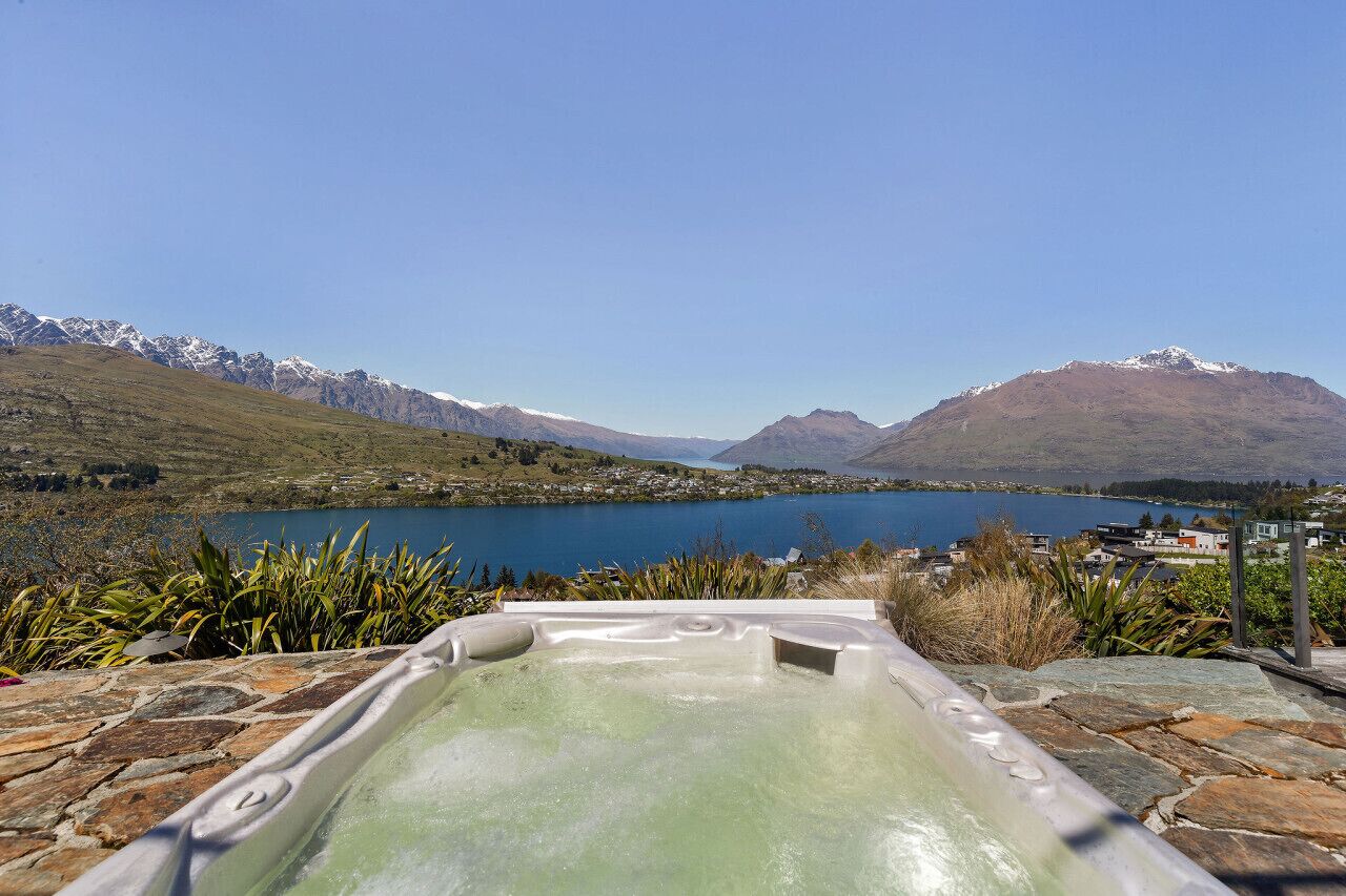 Un bain à remous avec vue sur un lac, des montagnes en toile de fond.