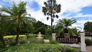 A sign for Excelsior Beach to Bay condominiums with a landscaped garden and a fountain. - Spacious Condo in a Great Location! Private Beach, 2 Pools, 2 Jaccuzi, Fishing Deck & More! (Siesta Key)