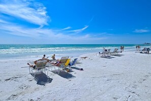 Une plage avec des transats et des gens qui se détendent.