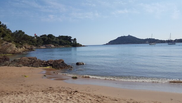 A beach with rocky shoreline, calm water, and a distant hill. - Studio-cabin in RDJ, with your feet in the water! (Antheor)