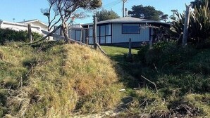 Una casa amb un pati tancat, un arbre i un cel serè.