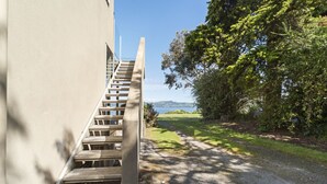 A staircase leading to a building with a view of a body of water and greenery. - Lakeside Vistas Magic - Rainbow Point Home (Rainbow Point)