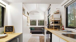 Une cuisine compacte dotée d’un plan de travail en bois, d’un évier encastré et d’un coin repas avec un canapé.