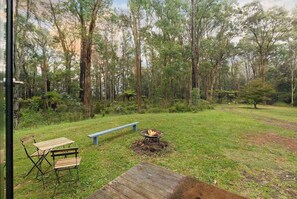 An outdoor seating area with a fire pit, a bench, and a table.