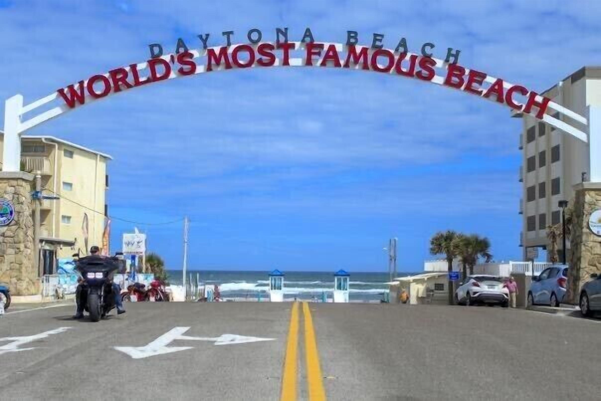 A road leading to Daytona Beach with a sign stating 'World's Most Famous Beach.'