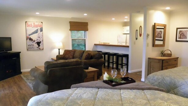 A cozy living room with a sofa, a dining area with a table and chairs, a kitchen area, and a bed with a decorative tray. - Extra Clean Next Beech Mountain Ski Resort (Beech Mountain)