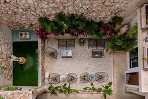 A rooftop terrace with a stone wall, a small water feature, and several wind chimes.