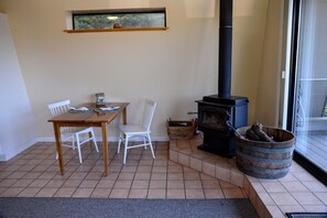 Un comedor con mesa y sillas, chimenea y ventana con vistas.